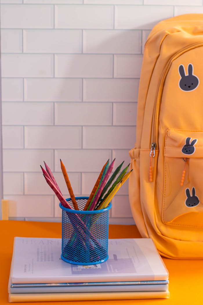 Colorful school supplies scene featuring a backpack and stationery on a desk.